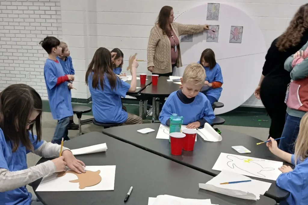kids working on a coloring assignment at different tables